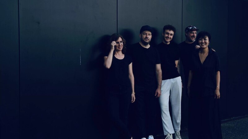 Fünf Personen in schwarzer Kleidung stehen lächelnd vor einer dunklen Wand. Sie wirken entspannt und freundlich., © Jazzclub Schwäbisch Hall e.V. Fünf Personen in schwarzer Kleidung stehen lächelnd vor einer dunklen Wand. Sie wirken entspannt und freundlich., © Jazzclub Schwäbisch Hall e.V.