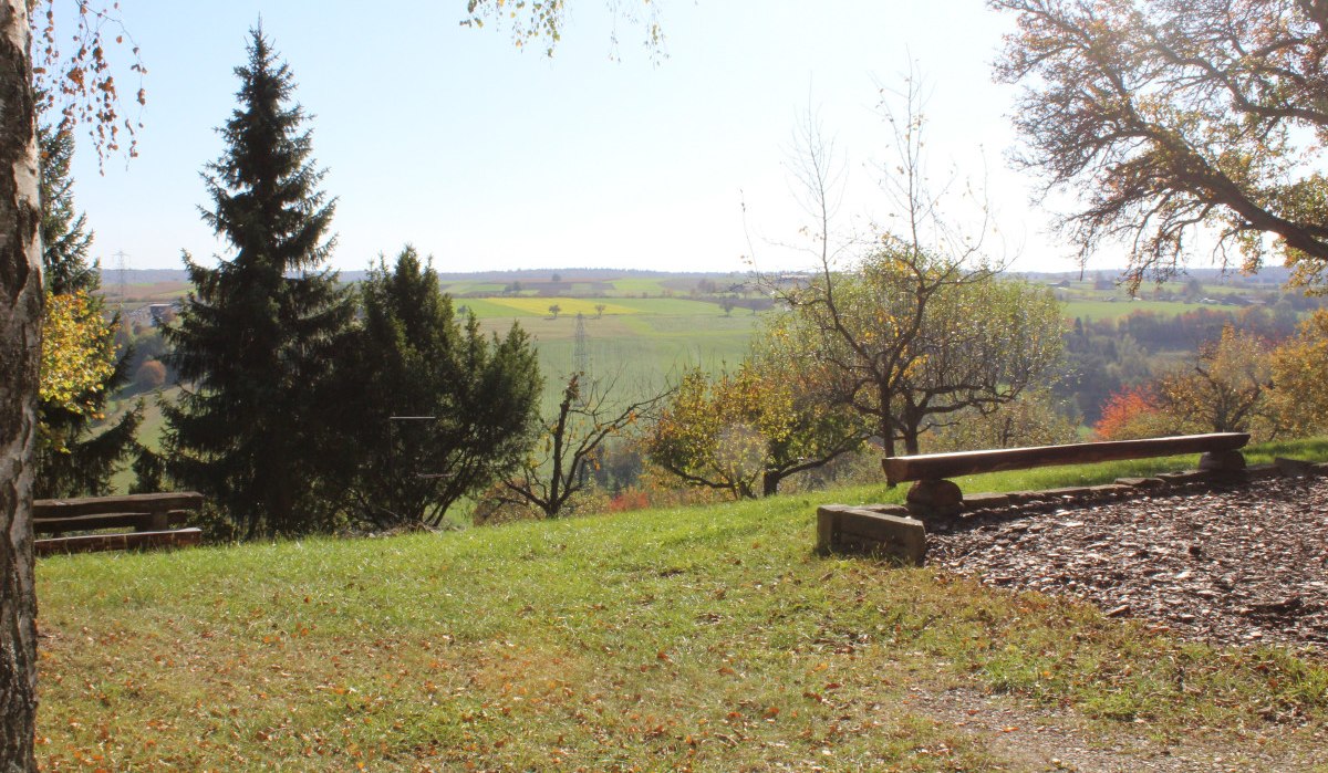 Holzbank auf einer Wiese mit Blick auf eine weite, grüne Landschaft und Bäume im Hintergrund., © Natur.Nah. Schönbuch & Heckengäu Holzbank auf einer Wiese mit Blick auf eine weite, grüne Landschaft und Bäume im Hintergrund., © Natur.Nah. Schönbuch & Heckengäu