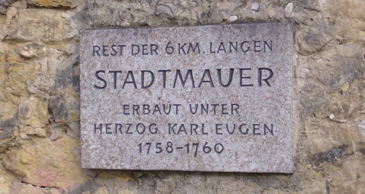 Gedenktafel an einer alten Stadtmauer. Text: "Rest der 6 km langen Stadtmauer, erbaut unter Herzog Karl Eugen 1758-1760.", © Ludwigsburg - Stuttgart-Marketing GmbH Gedenktafel an einer alten Stadtmauer. Text: "Rest der 6 km langen Stadtmauer, erbaut unter Herzog Karl Eugen 1758-1760.", © Ludwigsburg - Stuttgart-Marketing GmbH