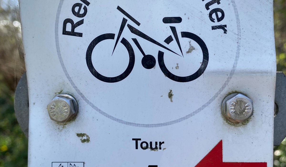 Schild mit 'Remseck-Achter', Fahrradsymbol, 'Tour 1' und rotem Pfeil nach links. Unten das Wappen von Remseck am Neckar. Schild mit 'Remseck-Achter', Fahrradsymbol, 'Tour 1' und rotem Pfeil nach links. Unten das Wappen von Remseck am Neckar.