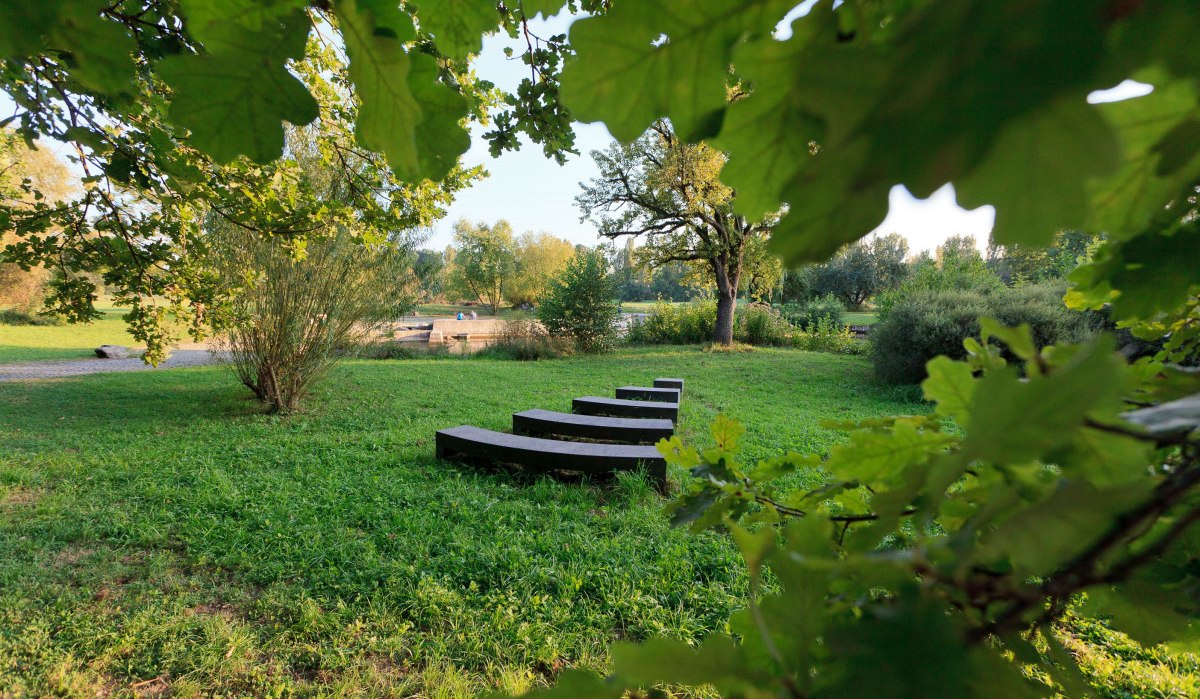 Ein grüner Park mit geschwungenen Bänken, umgeben von Bäumen und Büschen. Die Szene wirkt ruhig und einladend., © Remstal Tourismus e.V.
