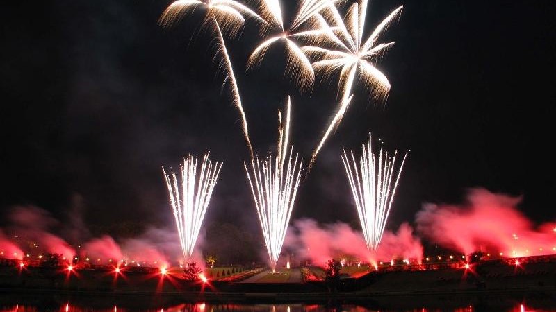 Ein spektakul&auml;res Feuerwerk mit wei&szlig;en und roten Effekten, das sich in einem Gew&auml;sser spiegelt. Der Nachthimmel ist hell erleuchtet., &copy; copyright: Marc Sansone