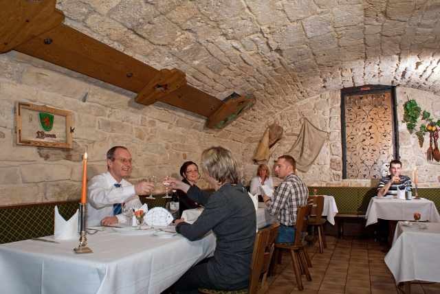 Ein rustikales Gewölberestaurant mit Steinwänden. Gäste sitzen an Tischen, genießen Essen und Getränke. Eine gemütliche Atmosphäre mit Kerzenlicht., © Ulli Kellenbenz Ein rustikales Gewölberestaurant mit Steinwänden. Gäste sitzen an Tischen, genießen Essen und Getränke. Eine gemütliche Atmosphäre mit Kerzenlicht., © Ulli Kellenbenz