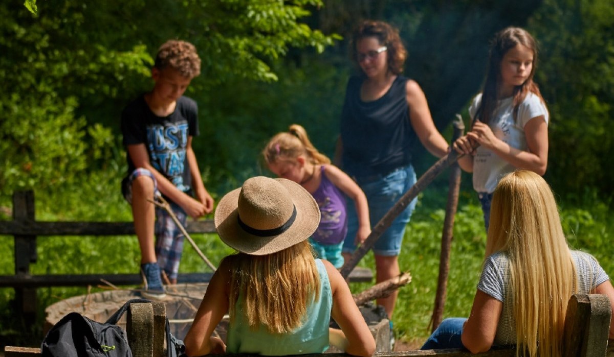 Eine Gruppe von Menschen sitzt und steht um einen Rastplatz im Wald. Sie scheinen sich zu unterhalten und die Natur zu genießen., © Natur.Nah. Schönbuch & Heckengäu