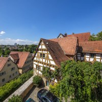 Fachwerkh&auml;user mit roten D&auml;chern und B&auml;umen im Vordergrund, blauer Himmel im Hintergrund., &copy; Achim Mende