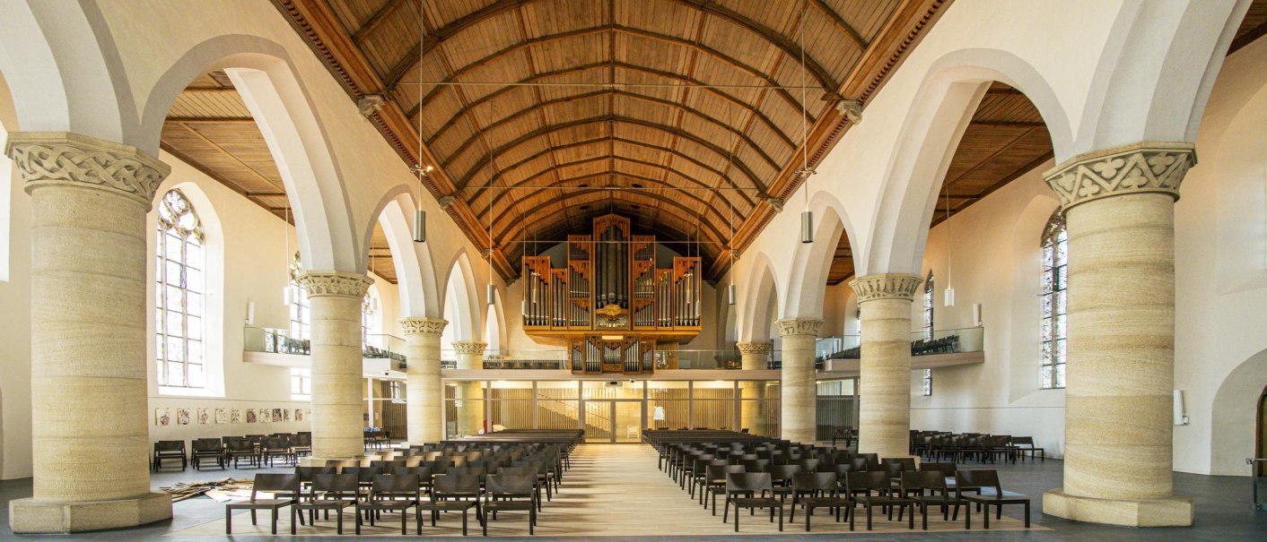 Innenansicht der Martinskirche in Kirchheim unter Teck. Sicht auf die Orgel, hohe Säulen und Sitzreihen. Hölzerne Decke und große Fenster., © SMG, Sarah Schmid Innenansicht der Martinskirche in Kirchheim unter Teck. Sicht auf die Orgel, hohe Säulen und Sitzreihen. Hölzerne Decke und große Fenster., © SMG, Sarah Schmid