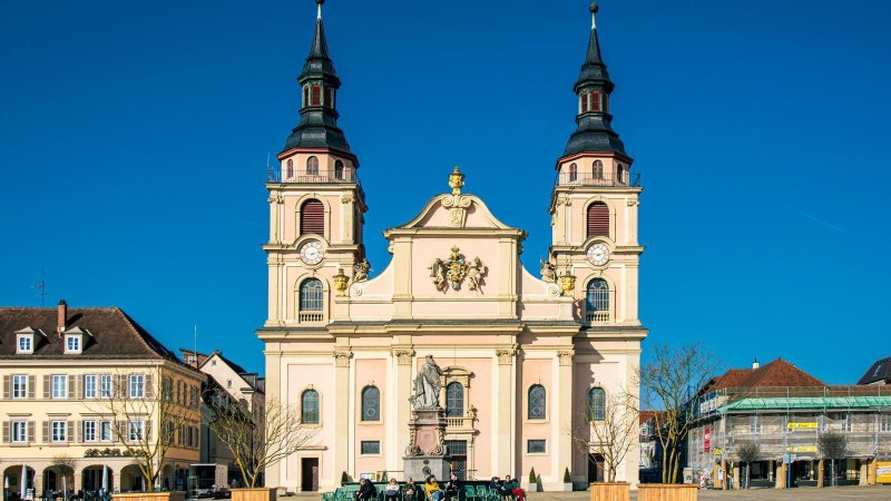 Der Marktplatz in Ludwigsburg zeigt eine pr&auml;chtige Kirche mit zwei T&uuml;rmen, umgeben von historischen Geb&auml;uden unter einem strahlend blauen Himmel., &copy; Stuttgart-Marketing GmbH, Sarah Schmid