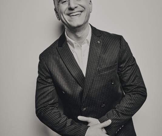 Ein Mann in einem gestreiften Anzug l&auml;chelt in die Kamera. Das Bild ist in Schwarz-Wei&szlig; gehalten., &copy; Ludwigsburg