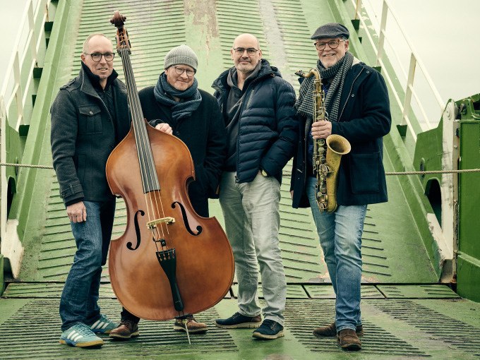Vier Männer posieren auf einer grünen Rampe. Einer hält einen Kontrabass, ein anderer ein Saxophon. Sie tragen Winterkleidung und lächeln in die Kamera., © Stadt Waldenbuch Vier Männer posieren auf einer grünen Rampe. Einer hält einen Kontrabass, ein anderer ein Saxophon. Sie tragen Winterkleidung und lächeln in die Kamera., © Stadt Waldenbuch