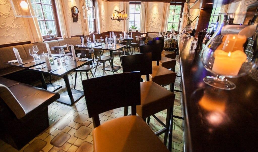 Gemütliche Bar mit gedeckten Tischen, Kerzenlicht und einer langen Theke. Holzmöbel und warme Beleuchtung schaffen eine einladende Atmosphäre., © Hotel Waldhorn Gemütliche Bar mit gedeckten Tischen, Kerzenlicht und einer langen Theke. Holzmöbel und warme Beleuchtung schaffen eine einladende Atmosphäre., © Hotel Waldhorn