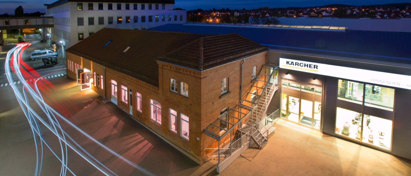 Nachtaufnahme des Kärcher Museums in Winnenden. Ein beleuchtetes Backsteingebäude mit Lichtspuren von Autos im Vordergrund., © SMG Achim Mende Nachtaufnahme des Kärcher Museums in Winnenden. Ein beleuchtetes Backsteingebäude mit Lichtspuren von Autos im Vordergrund., © SMG Achim Mende