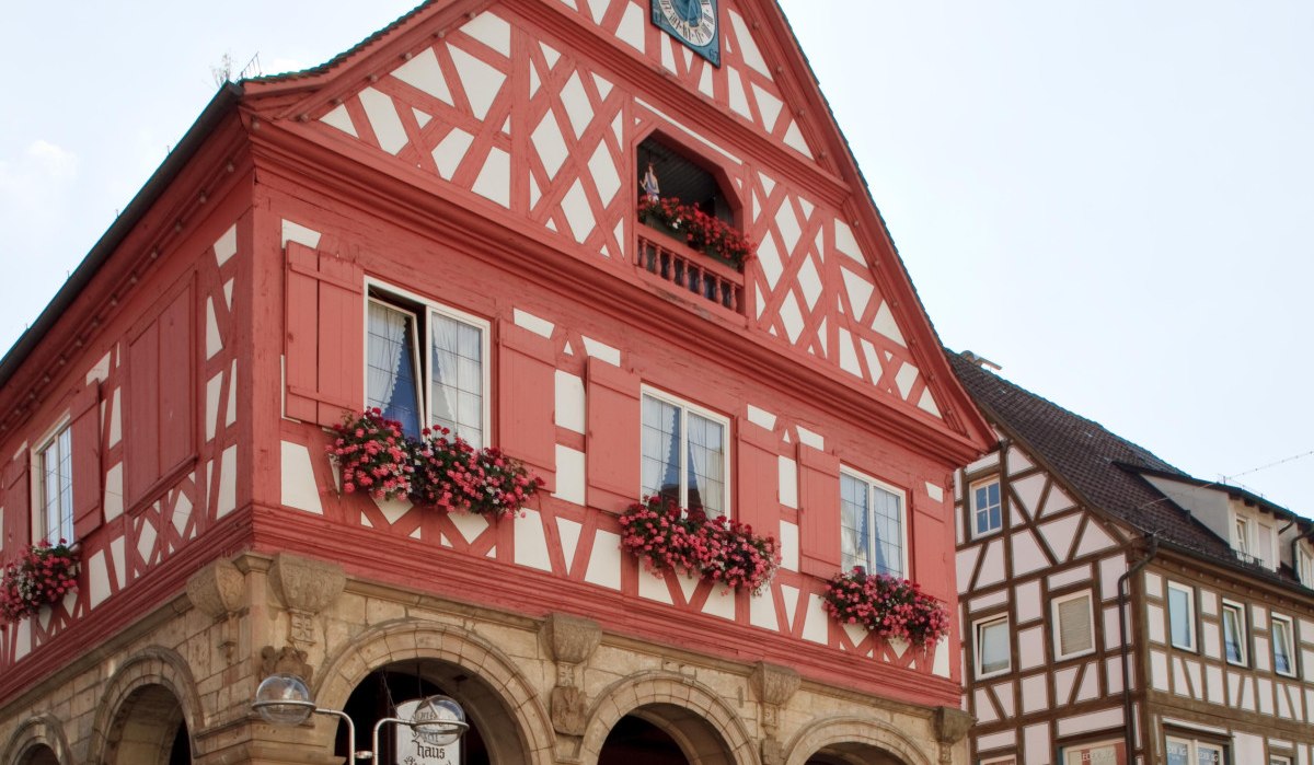 Fachwerk-Rathaus mit Uhrturm, roten und weißen Balken, Blumen an den Fenstern und Arkaden im Erdgeschoss. Klarer Himmel im Hintergrund., © Waiblingen - Stuttgart-Marketing GmbH Fachwerk-Rathaus mit Uhrturm, roten und weißen Balken, Blumen an den Fenstern und Arkaden im Erdgeschoss. Klarer Himmel im Hintergrund., © Waiblingen - Stuttgart-Marketing GmbH