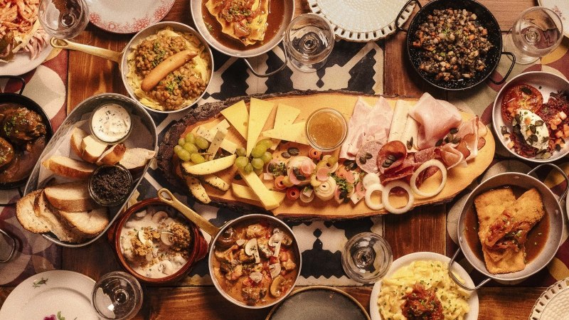 Ein Tisch voller traditioneller deutscher Speisen, darunter Käse, Wurst, Brot, Linsen, Kartoffeln und verschiedene Beilagen., © Gasthaus Bären Stuttgart Ein Tisch voller traditioneller deutscher Speisen, darunter Käse, Wurst, Brot, Linsen, Kartoffeln und verschiedene Beilagen., © Gasthaus Bären Stuttgart
