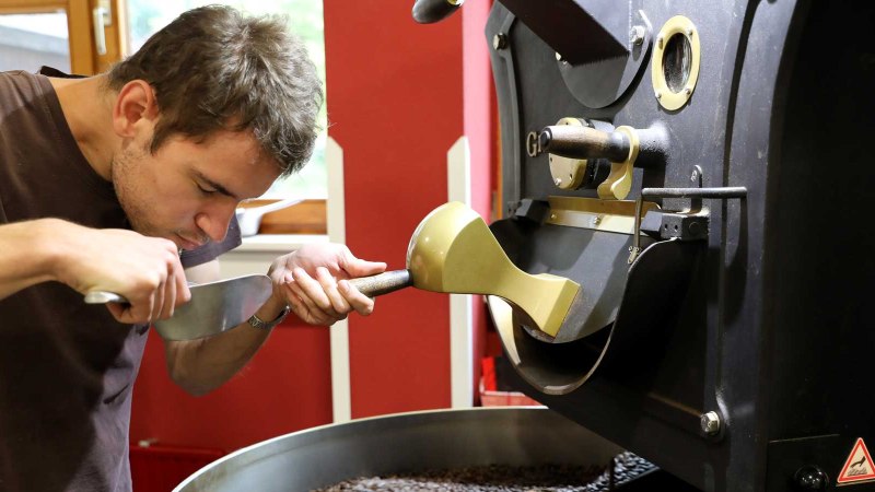 Ein Mann pr&uuml;ft den Duft von frisch ger&ouml;steten Kaffeebohnen in einer R&ouml;stmaschine. Er konzentriert sich auf das Aroma der Bohnen., &copy; EINS + Alles/Christopherus e. V.