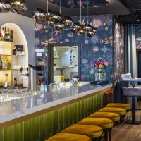 Eleganter Gastraum mit Marmortheke, gelben Hockern und stilvoller Beleuchtung. Die Bar ist gut bestückt, mit Gläsern und Flaschen dekoriert., © SMG, Sarah Schmid Eleganter Gastraum mit Marmortheke, gelben Hockern und stilvoller Beleuchtung. Die Bar ist gut bestückt, mit Gläsern und Flaschen dekoriert., © SMG, Sarah Schmid