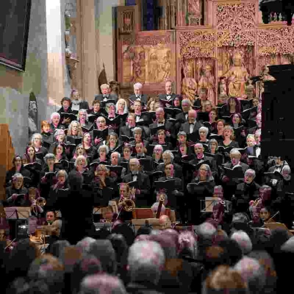 Ein großer Chor und Orchester führen in einer Kirche ein Konzert auf. Der Chor steht vor einem kunstvoll geschnitzten Altar., © Evangelische Kirchengemeinde Winnenden Ein großer Chor und Orchester führen in einer Kirche ein Konzert auf. Der Chor steht vor einem kunstvoll geschnitzten Altar., © Evangelische Kirchengemeinde Winnenden