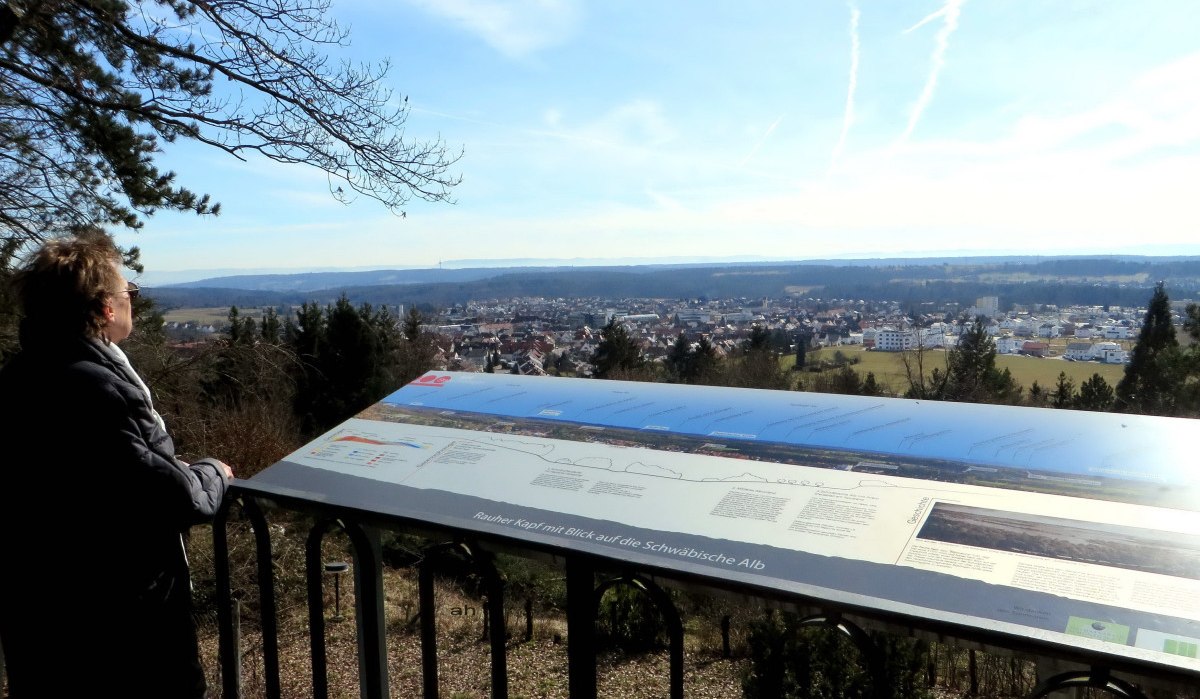 Person steht auf einer Aussichtsplattform am Rauhen Kapf und blickt über eine Stadtlandschaft. Eine Infotafel beschreibt die Schwäbische Alb., © Schwäbischer Albverein, Ortsgruppe Böblingen Person steht auf einer Aussichtsplattform am Rauhen Kapf und blickt über eine Stadtlandschaft. Eine Infotafel beschreibt die Schwäbische Alb., © Schwäbischer Albverein, Ortsgruppe Böblingen