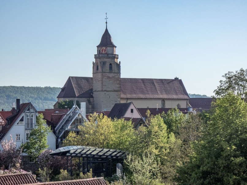 Die Stadtkirche mit ihrem markanten Turm erhebt sich über die Dächer und Bäume der Stadt, vor einem klaren blauen Himmel., © statdmarketing Die Stadtkirche mit ihrem markanten Turm erhebt sich über die Dächer und Bäume der Stadt, vor einem klaren blauen Himmel., © statdmarketing