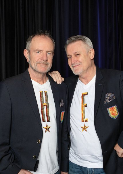 Zwei Männer in schwarzen Blazern und weißen T-Shirts mit den Buchstaben H und E stehen vor einem dunklen Vorhang und lächeln in die Kamera., © Stadt Leinfelden-Echterdingen, Kulturamt Zwei Männer in schwarzen Blazern und weißen T-Shirts mit den Buchstaben H und E stehen vor einem dunklen Vorhang und lächeln in die Kamera., © Stadt Leinfelden-Echterdingen, Kulturamt