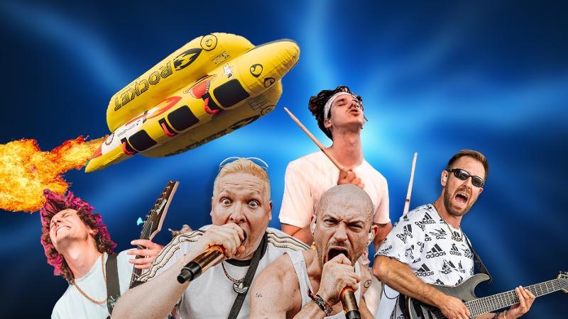 Musiker mit Gitarren und Mikrofonen vor blauem Hintergrund. Ein gelbes Schlauchboot fliegt darüber, umgeben von Flammen., © Music Circus Concertbüro GmbH & Co. KG