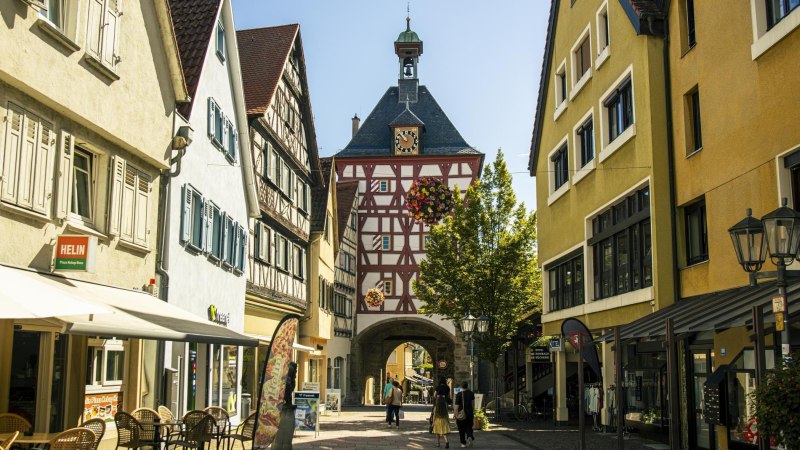 Historisches Stadttor in Bietigheim-Bissingen mit Fachwerk und Uhr, umgeben von alten Gebäuden und Geschäften., © Stuttgart Marketing GmbH, Sarah Schmid Historisches Stadttor in Bietigheim-Bissingen mit Fachwerk und Uhr, umgeben von alten Gebäuden und Geschäften., © Stuttgart Marketing GmbH, Sarah Schmid