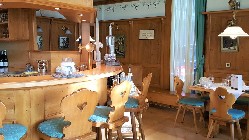 Holzvertäfelte Bar mit rustikalen Stühlen und Tisch im Erikson Hotel. Dekorative Bilder und Flaschen auf der Theke, gemütliche Atmosphäre., © Erikson Hotel Sindelfingen Holzvertäfelte Bar mit rustikalen Stühlen und Tisch im Erikson Hotel. Dekorative Bilder und Flaschen auf der Theke, gemütliche Atmosphäre., © Erikson Hotel Sindelfingen