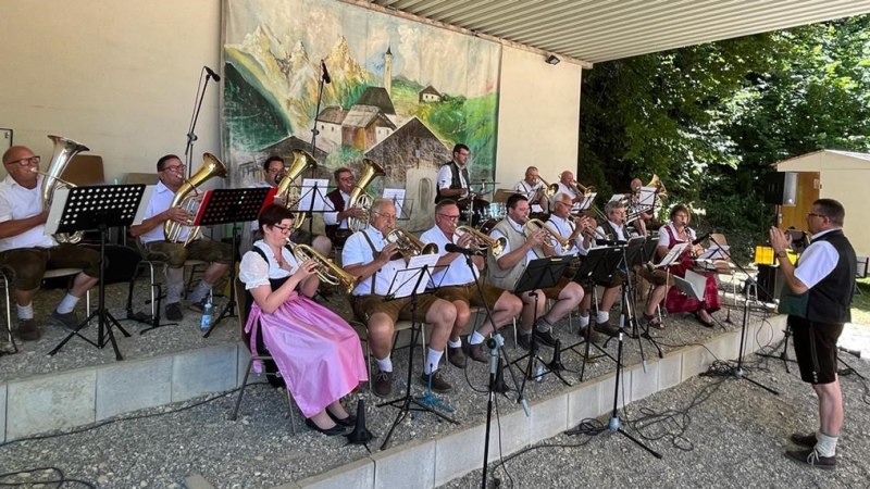 Die Kogelschdoiner Musikanten spielen in traditioneller Tracht auf einer Freilichtbühne. Die Musiker sind mit Blasinstrumenten ausgestattet., © Kogelschdoiner Die Kogelschdoiner Musikanten spielen in traditioneller Tracht auf einer Freilichtbühne. Die Musiker sind mit Blasinstrumenten ausgestattet., © Kogelschdoiner
