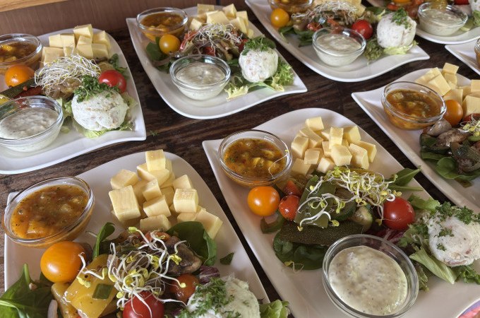 Teller mit Tapas: K&auml;sew&uuml;rfel, Tomaten, Saucen und Salat auf einem Holztisch arrangiert., &copy; Cool-Tours StattReisen
