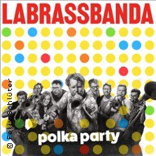 LaBrassBanda Polka Party Tour 2026: Bandfoto mit Blasinstrumenten vor buntem Punktmuster. Titel in Rot und Weiß., © links im Bild