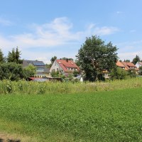 Häuser mit Solarpanelen am Ortsrand, umgeben von Bäumen und grünen Feldern unter blauem Himmel., © Ludwigsburg - Stuttgart-Marketing GmbH