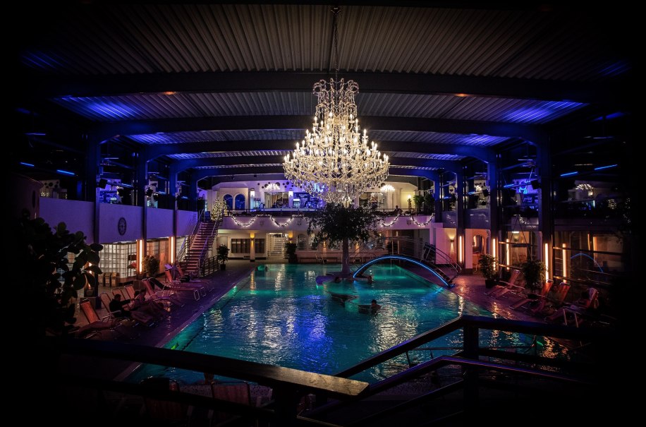 Gro&szlig;er Kronleuchter beleuchtet einen Innenpool in den AlbThermen, umgeben von Liegest&uuml;hlen und stimmungsvoller Beleuchtung., &copy; AlbThermen