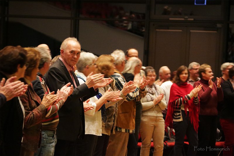 Eine Gruppe von Menschen steht in einer Reihe und applaudiert in einem Veranstaltungsraum. Die Atmosph&auml;re wirkt festlich und gemeinschaftlich., &copy; Sch&ouml;nblick gemeinn&uuml;tzige GmbH