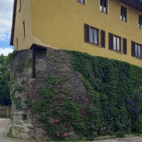 Stadtmauer und ehemaliger Wachturm in der Grabenstra&szlig;e - Gelbes Haus an der Stra&szlig;e. Die Au&szlig;enwand des Erdgeschoss ist die alte Stadtmauer. Sie besteht aus gro&szlig;en gemauerten Steinen und ist mit Efeu bewachsen. Der Himmel ist leicht bew&ouml;lkt., &copy; Petra Natzkowski