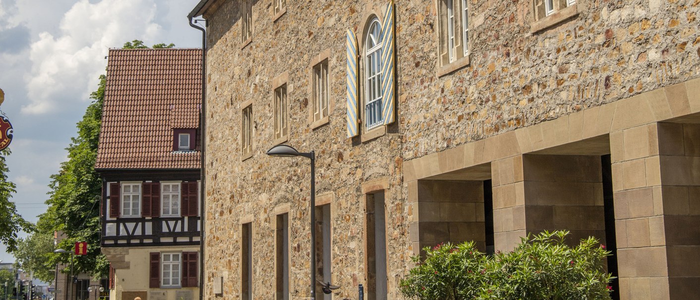 Das Kornhaus in Kirchheim unter Teck mit Fachwerkhaus und blauen Fensterläden, umgeben von Bäumen und einem klaren Himmel., © Achim Mende Das Kornhaus in Kirchheim unter Teck mit Fachwerkhaus und blauen Fensterläden, umgeben von Bäumen und einem klaren Himmel., © Achim Mende