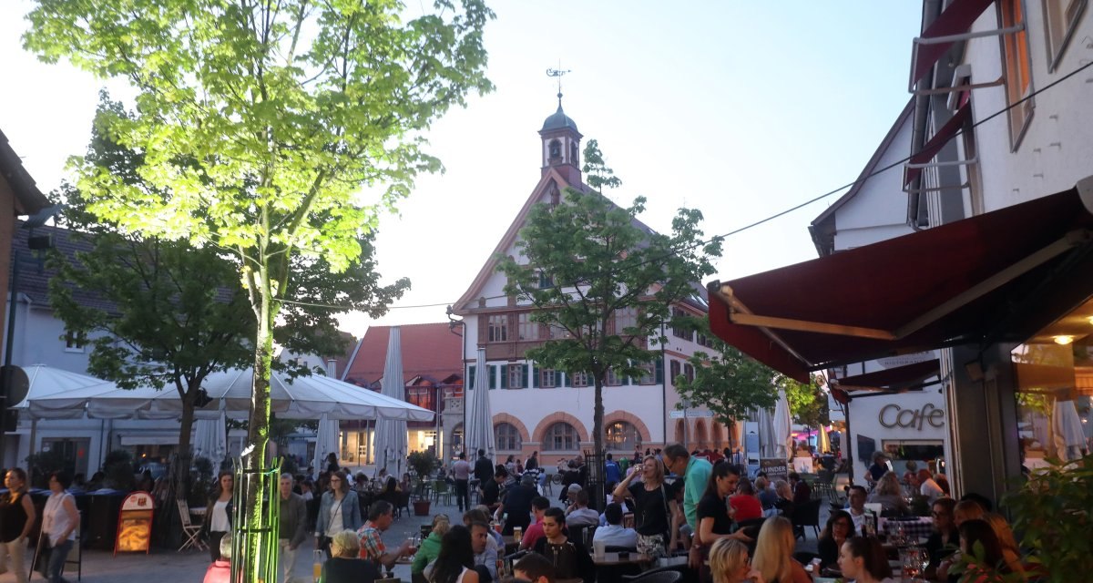 Belebte Café-Szene in der Metzinger Innenstadt mit Blick auf das historische Rathaus im Hintergrund. Belebte Café-Szene in der Metzinger Innenstadt mit Blick auf das historische Rathaus im Hintergrund.