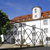 Schloss Waldenbuch mit wei&szlig;er Fassade und rotem Dach, umgeben von B&auml;umen. Ein schmiedeeisernes Gel&auml;nder im Vordergrund., &copy; Gert-Peter Albig, GDA Waldenbuch