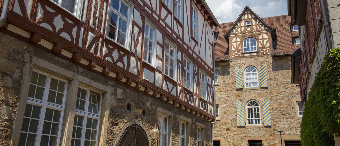 Fachwerkgebäude in Kirchheim unter Teck mit verzierten Fenstern und Türen. Historische Architektur mit roten und weißen Balken., © Achim Mende Fachwerkgebäude in Kirchheim unter Teck mit verzierten Fenstern und Türen. Historische Architektur mit roten und weißen Balken., © Achim Mende