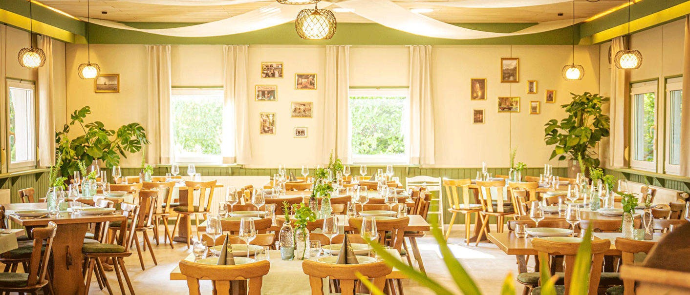 Gemütliches Restaurant mit Holzmöbeln, Pflanzen und dekorativen Lichtern. Tische sind gedeckt, Bilder an den Wänden, helle und einladende Atmosphäre., © FreCla Gastronomiebetriebe GmbH Gemütliches Restaurant mit Holzmöbeln, Pflanzen und dekorativen Lichtern. Tische sind gedeckt, Bilder an den Wänden, helle und einladende Atmosphäre., © FreCla Gastronomiebetriebe GmbH