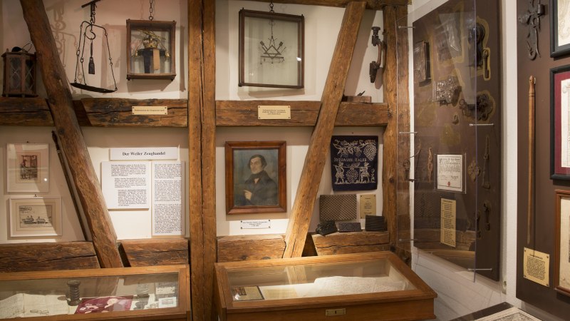 Ein Ausstellungsraum im Stadtmuseum zeigt historische Dokumente, Bilder und Werkzeuge. Holzbalken und Vitrinen pr&auml;gen das Ambiente., &copy; Stadtverwaltung Weil der Stadt