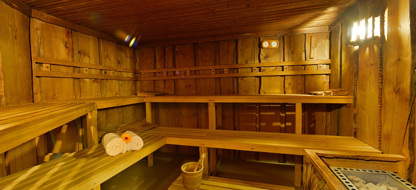 Holzsauna mit B&auml;nken, Handt&uuml;chern und Saunaofen. Gem&uuml;tliche Beleuchtung und rustikales Ambiente., &copy; Amber Hotel Leonberg / Stuttgart