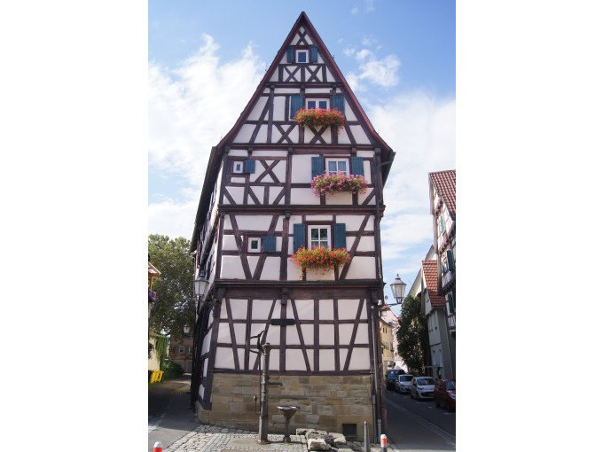Ein schmales Fachwerkhaus in Schorndorf mit bunten Blumen an den Fenstern, unter blauem Himmel., © Eigenbetrieb Tourismus und Citymanagement Schorndorf Ein schmales Fachwerkhaus in Schorndorf mit bunten Blumen an den Fenstern, unter blauem Himmel., © Eigenbetrieb Tourismus und Citymanagement Schorndorf