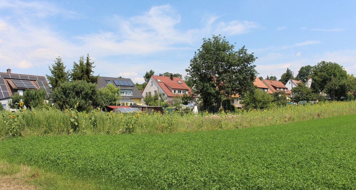 Häuser mit Solarpanelen am Ortsrand, umgeben von Bäumen und grünen Feldern unter blauem Himmel., © Ludwigsburg - Stuttgart-Marketing GmbH