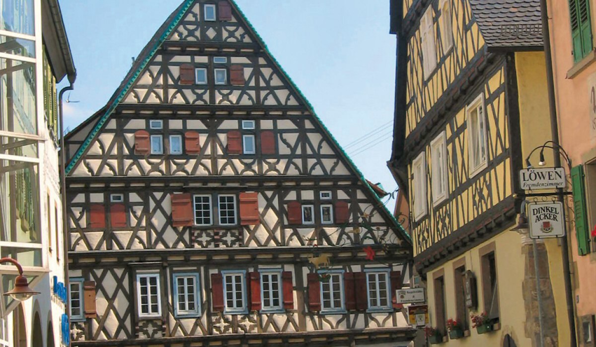 Fachwerkhäuser in Vaihingen-Enzweihingen, Deutschland. Ein Mann überquert die Straße bei sonnigem Wetter. Historische Architektur im Vordergrund., © Land der 1000 Hügel - Kraichgau-Stromberg Fachwerkhäuser in Vaihingen-Enzweihingen, Deutschland. Ein Mann überquert die Straße bei sonnigem Wetter. Historische Architektur im Vordergrund., © Land der 1000 Hügel - Kraichgau-Stromberg