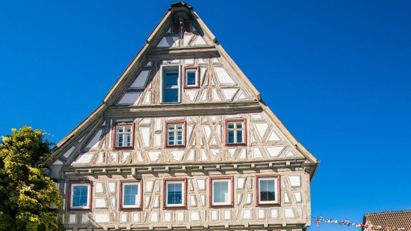 Ein traditionelles Fachwerkhaus in Besigheim, umgeben von klarem, blauem Himmel. Links ist eine grüne Pflanze zu sehen., © Stuttgart-Marketing GmbH, Sarah Schmid Ein traditionelles Fachwerkhaus in Besigheim, umgeben von klarem, blauem Himmel. Links ist eine grüne Pflanze zu sehen., © Stuttgart-Marketing GmbH, Sarah Schmid