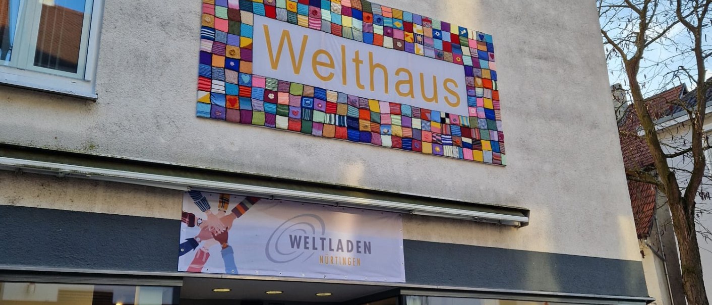 Das Welthaus in N&uuml;rtingen zeigt ein buntes Schild. Darunter befindet sich der Eingang zum Weltladen mit ausgestellten Waren., &copy; StadtNuertingen