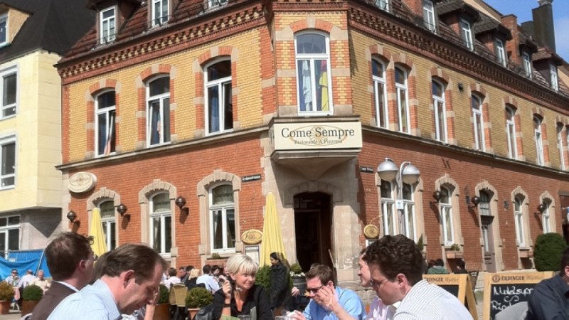 Menschen genie&szlig;en das sonnige Wetter an einem Tisch vor dem historischen Geb&auml;ude 'Come Sempre' am Wettbachplatz in Sindelfingen., &copy; Sindelfingen - Stuttgart-Marketing GmbH