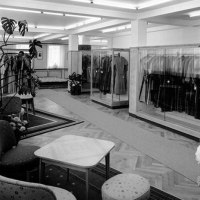 Elegantes Bekleidungsgeschäft mit Kleiderständern, Sitzbereich und Pflanzen. Schwarzweiß-Aufnahme mit stilvollem Interieur., © Stadt Göppingen