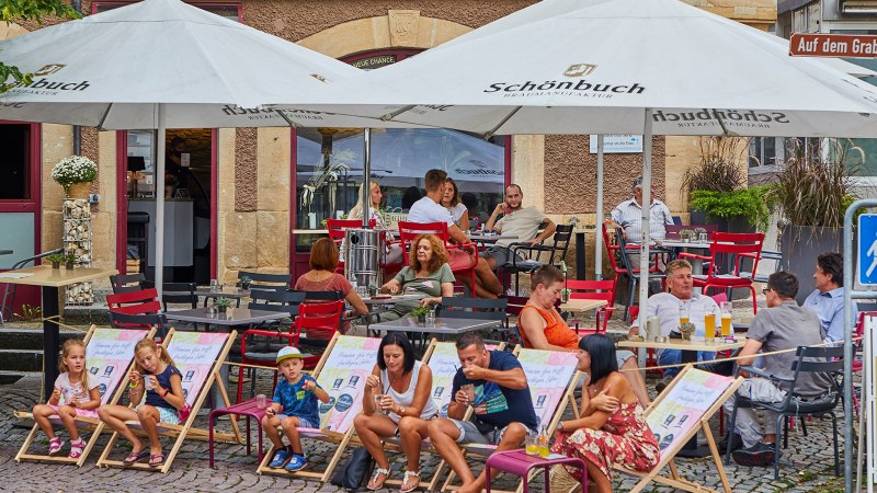 Menschen sitzen unter Sonnenschirmen vor dem FRIEDRICH Café in Waldenbuch. Kinder und Erwachsene entspannen auf Stühlen und Liegestühlen., © thomas ceska waldenbuch Menschen sitzen unter Sonnenschirmen vor dem FRIEDRICH Café in Waldenbuch. Kinder und Erwachsene entspannen auf Stühlen und Liegestühlen., © thomas ceska waldenbuch