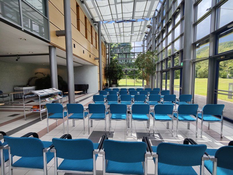 Ein leerer Konferenzraum mit blauen Stühlen, großen Fenstern und viel Tageslicht. Ein Tisch mit Broschüren steht bereit., © Bad Urach Tourismus Ein leerer Konferenzraum mit blauen Stühlen, großen Fenstern und viel Tageslicht. Ein Tisch mit Broschüren steht bereit., © Bad Urach Tourismus