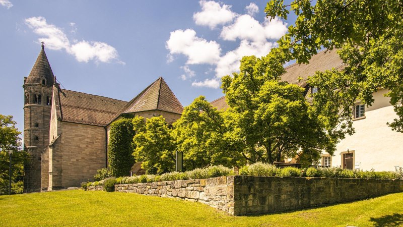 Das Kloster Lorch in einer sonnigen Landschaft mit grünen Bäumen und einem klaren blauen Himmel im Hintergrund., © SMG, Sarah Schmid Das Kloster Lorch in einer sonnigen Landschaft mit grünen Bäumen und einem klaren blauen Himmel im Hintergrund., © SMG, Sarah Schmid